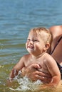 Cheerful child bathes in the water in her motherÃ¢â¬â¢s arms Royalty Free Stock Photo